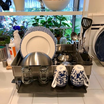 reviewer photo of the dish rack full of plates, mugs, utensils