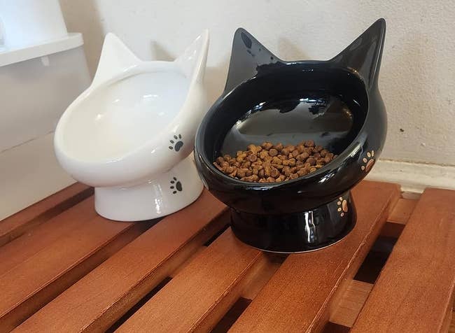 reviewer photo of the black and white raised cat bowls with cat ear design