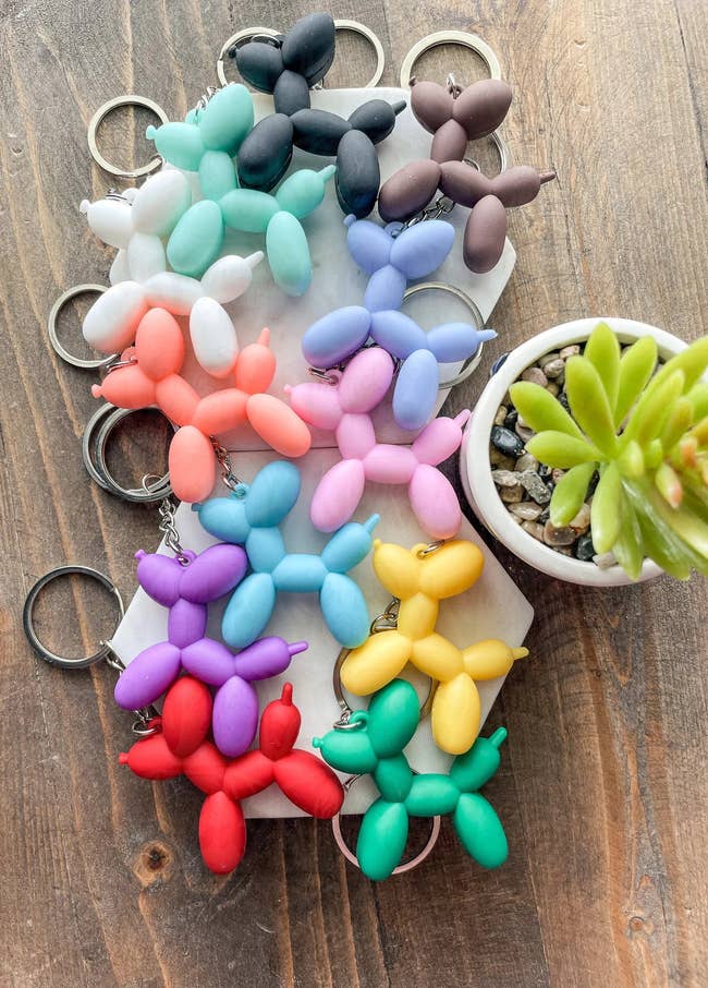 a dozen keychains that all look like balloon animal dogs 