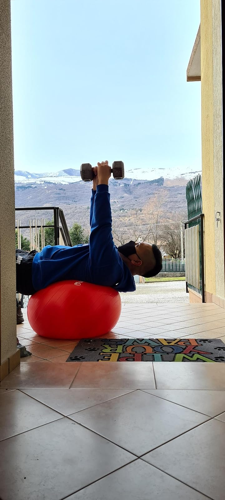 reviewer using the red exercise ball while lifting weights