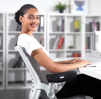 model using the armrest pads on a desk chair