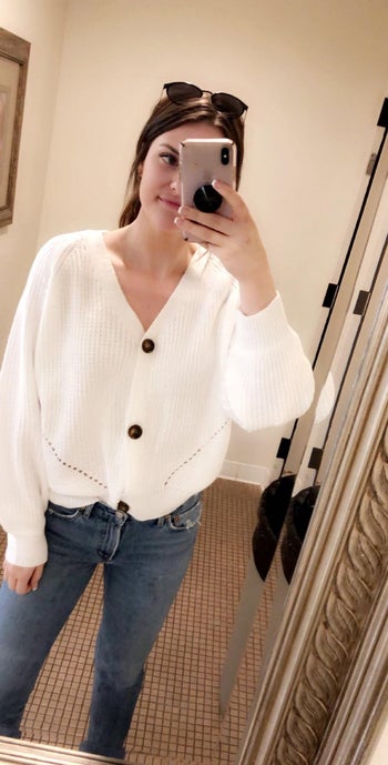 reviewer taking a selfie wearing the white version buttoned all the way up like a top