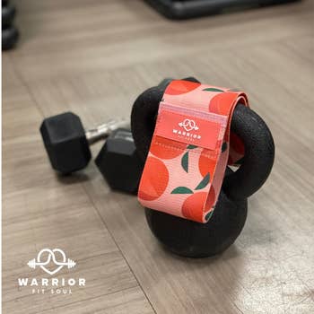the peach fitness band draped over a black kettlebell 