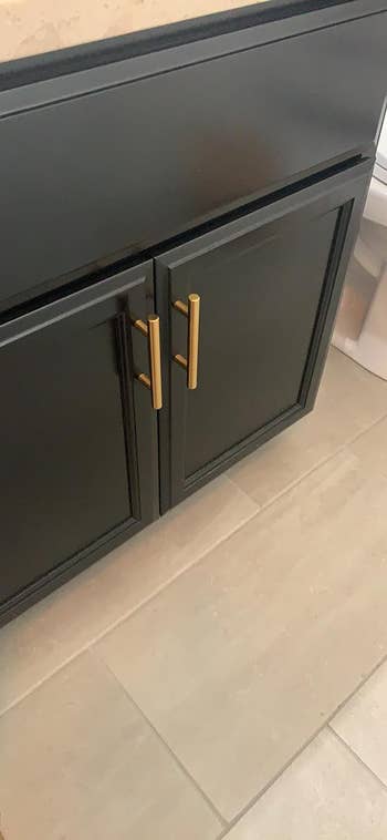reviewers black cabinet with gold knobs