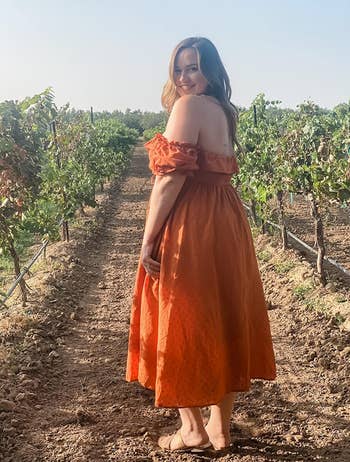 reviewer wearing the dress in orange 