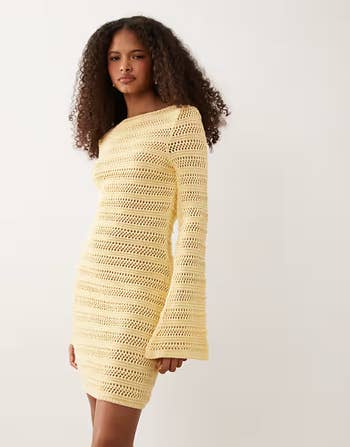 Person successful  a crochet knit formal  with agelong  sleeves stands against a plain background, styled casually suitable for buying  content