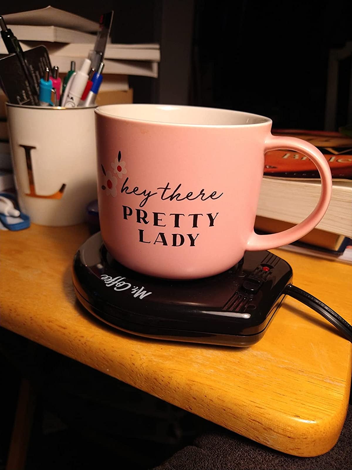 Reviewer photo of their pink mug on the black warmer
