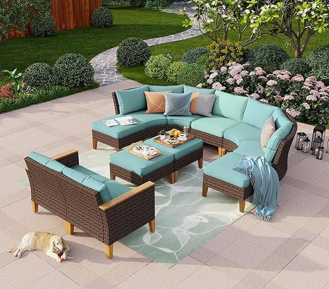 blue outdoor sectional set with half-moon shaped sofa, two armless chairs, two ottomans, and table