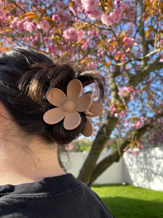 BuzzFeed editor wearing the tan flower clip in her hair
