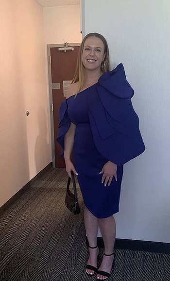 A reviewer wearing the dress in blue
