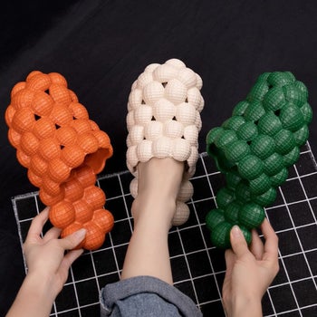 Model holding up the orange, white, and green versions 