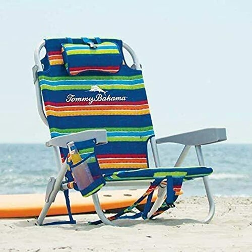 the colorful striped tommy bahama chair on a beach with a bottle in the side pouch