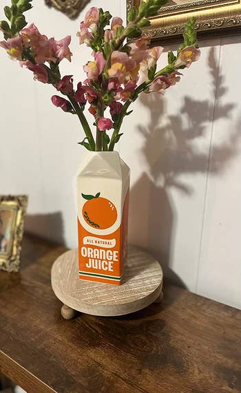 Ceramic vintage-pattern orange juice vase with flowers emerging from the spout 