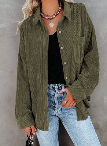 model wearing the dark green button-up over a black shirt and with light wash denim