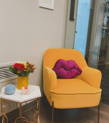 reviewer's purple lips pillow on a yellow chair 