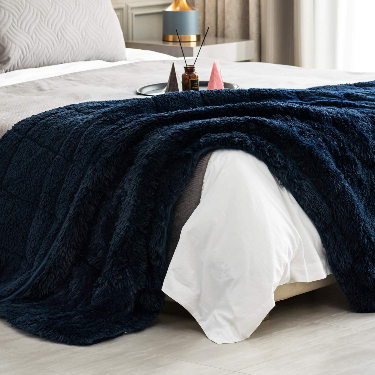 the navy blue blanket laying on a bed
