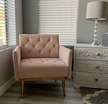 Reviewer image of pink tufted velvet chair with gold metal legs next to white and gray side table