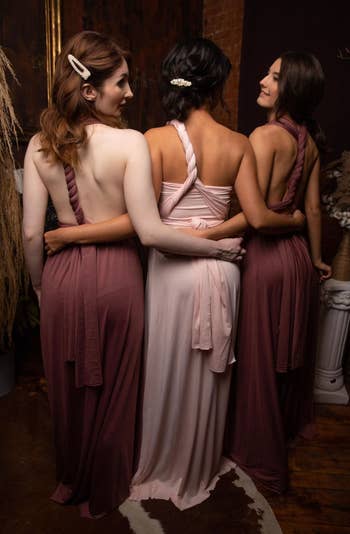 back view of three models wearing the dress in mauve and light pink
