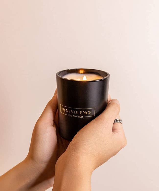 hands holding the black candle