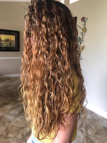 another reviewer's long hair with smooth, defined curls after using the product