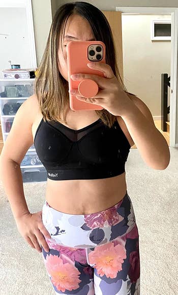 reviewer wearing the black bra with floral print leggings