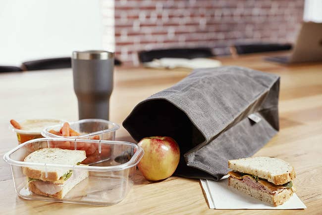 A black canvas lunch bag with food 