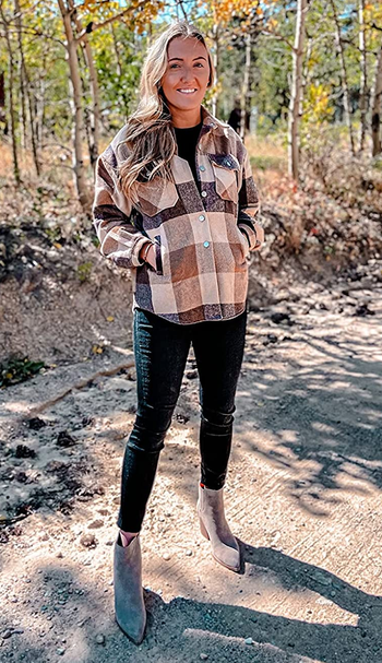 a reviewer wearing the shacket in brown and cream buttoned up over a pair of black jeans 