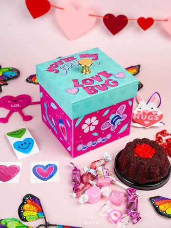 the box closed with candy, cake, and stickers surrounding it