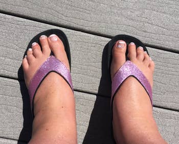 reviewer wearing glittery purple strap flip-flops 