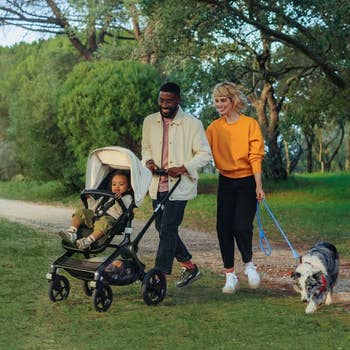 a couple walking with their child in a stroller