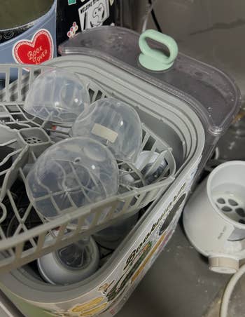 Baby vessel sterilizer with bottles and accessories inside, showing retention and cleaning setup