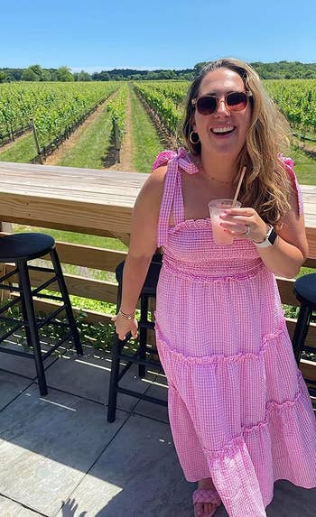 reviewer wearing the dress in pink checkered print without pom poms
