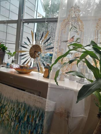 A windowsill decorated with sheer curtains with vertebrate  patterns