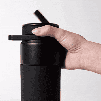 Model showing the twist function for touch-free sipping on a black Brümate water bottle