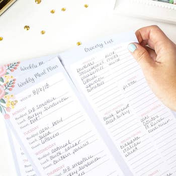 model holding meal plan pad, tearing off the grocery list