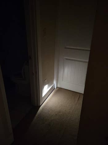 another reviewer photo of a darkened hallway with the night-light on showing how much light it gives off