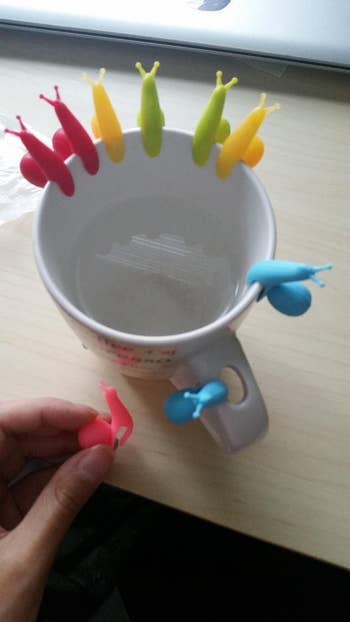 Reviewer's tea mug with the snail shape holders on the edge while holding another one of the snails