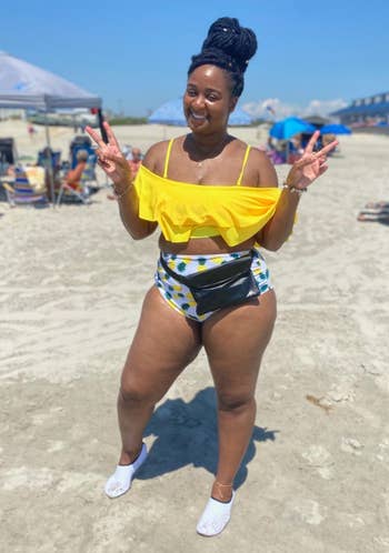 a reviewer wearing the ruffled top in yellow with printed bottom 