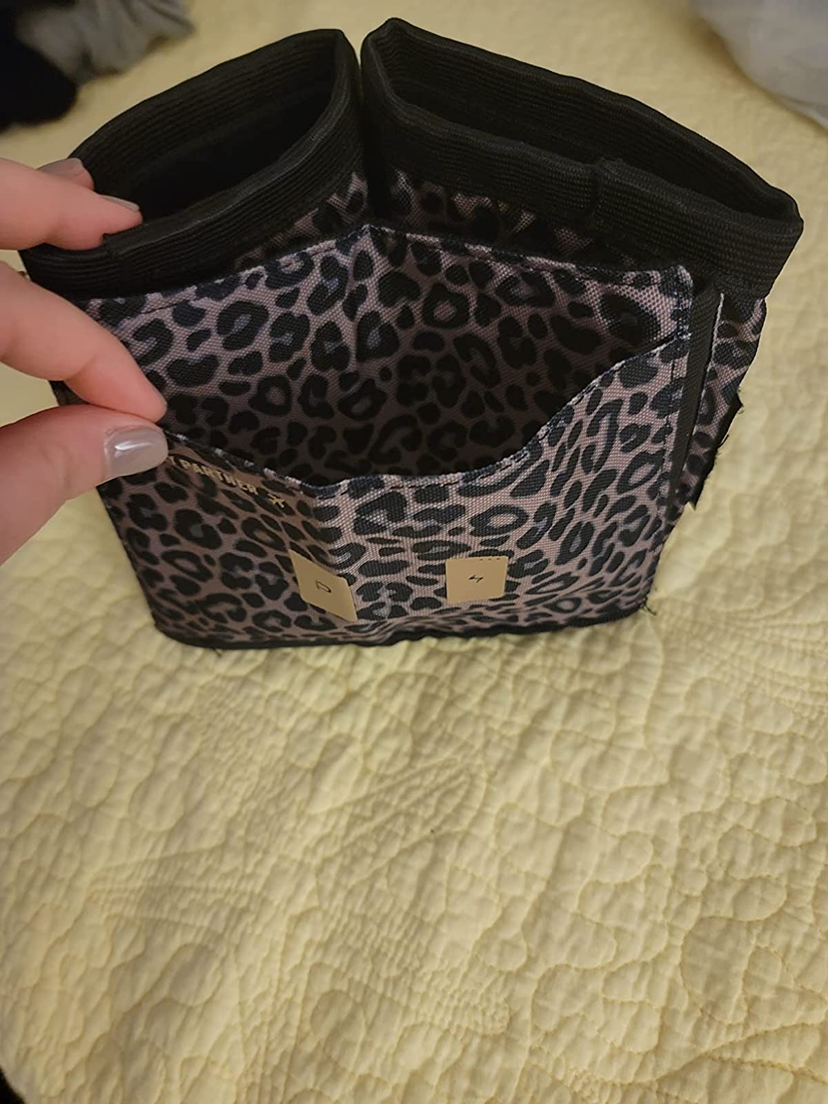 high down peep of the leopard print cupholder exhibiting the two cupholders and the stretchy sleeve that attaches to the suitcase handle