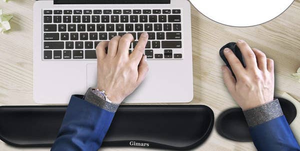 Model using keyboard and wrist memory foam set with laptop