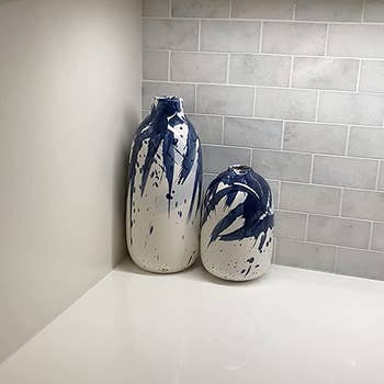 Reviewer image of short and tall white and blue painted vases on top of a white counter