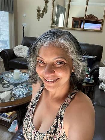 Person smiling successful a cozy surviving room, wearing a patterned top