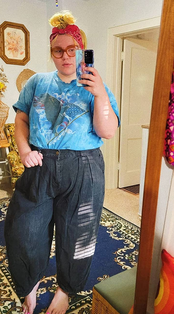 reviewer wearing the denim pants with a blue t-shirt