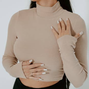 a model wearing a rib knit cropped top in tan
