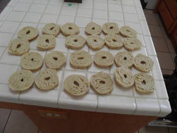 Reviewer's many sliced bagels cut by the bagel guillotine, lying on their counter