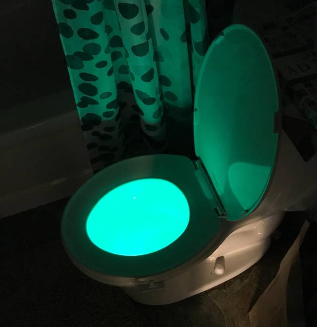 A lit up green toilet bowl 
