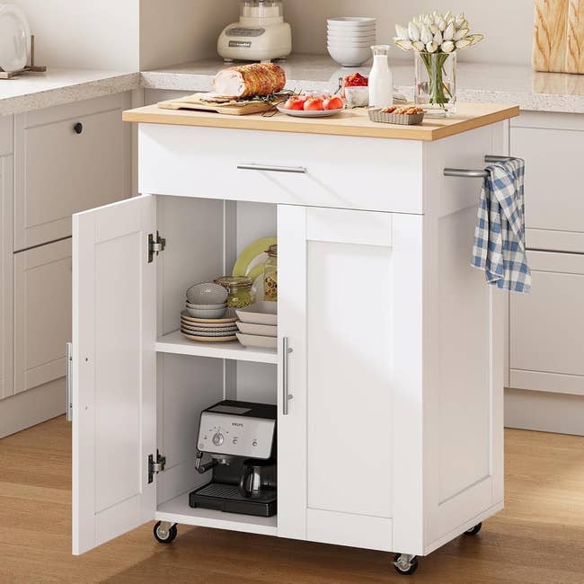 Kitchen cart with wood   top, unfastened  retention  with shelves and an espresso machine, wheels for mobility, and a manus  towel connected  the handle
