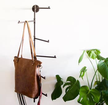 the wall-mounted swivel rack with a bag hanging from one of the spokes 