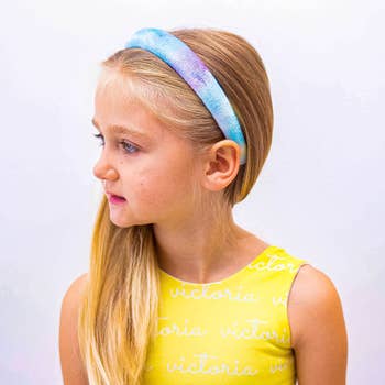 another child model in a blue and purple headband
