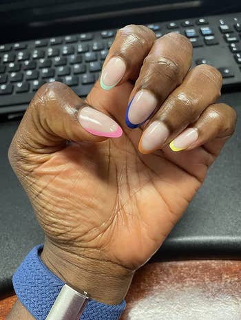 Reviewer with press on clear nails with rainbow tips 